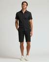 Man wearing The Timeless 9 Chino Shorts, black shirt, white sneakers.