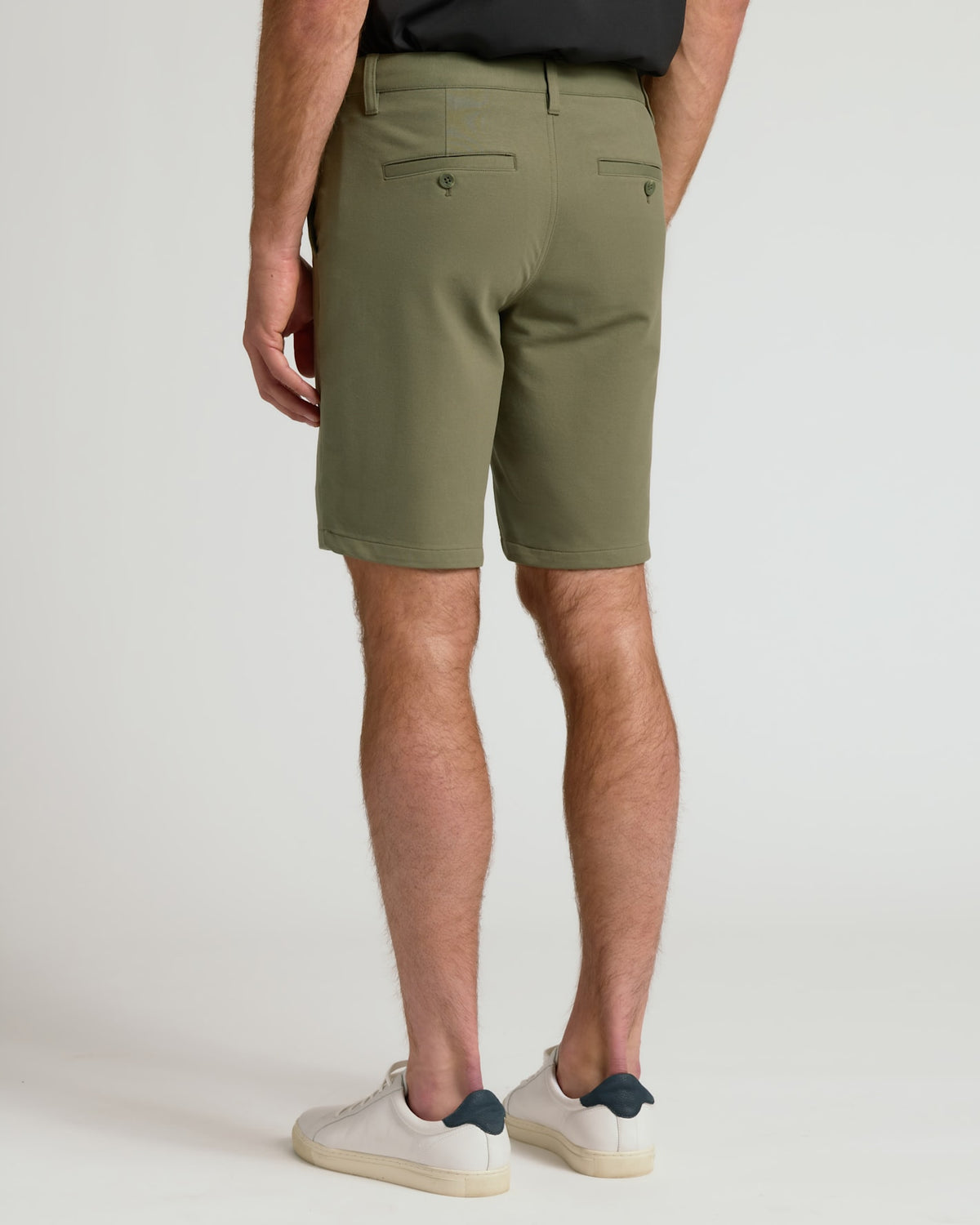Man wearing 9 Military Green Chino Shorts 2.0, showcasing back welt pockets.