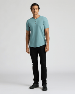 True ClassicMan wearing a light blue short-sleeve shirt with a three-button placket and curved hem paired with black pants and black shoes, showcasing the Heavyweight Curved Hem Henley 3-Pack.