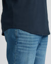 Close-up of a man wearing a Navy Tall Heavyweight Curved Hem Crew paired with light blue denim jeans, highlighting the curved hem detail and heavyweight fabric texture.