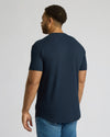 Man wearing a navy Navy Tall Heavyweight Curved Hem Crew shirt, shown from the back, paired with blue jeans against a plain background.