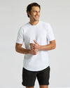 Man wearing a white t-shirt and black shorts on a light gray background