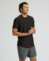 Man wearing a black t-shirt and gray shorts on a light gray background