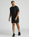 Man wearing a black t-shirt and shorts on a white background