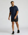 Man wearing a navy blue Tall Active Curved Hem Crew 6-Pack shirt paired with black shorts and sneakers, showcasing a comfortable and stylish men's basics activewear look.