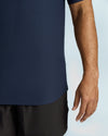 Person wearing a navy blue shirt and black shorts on a light gray background
