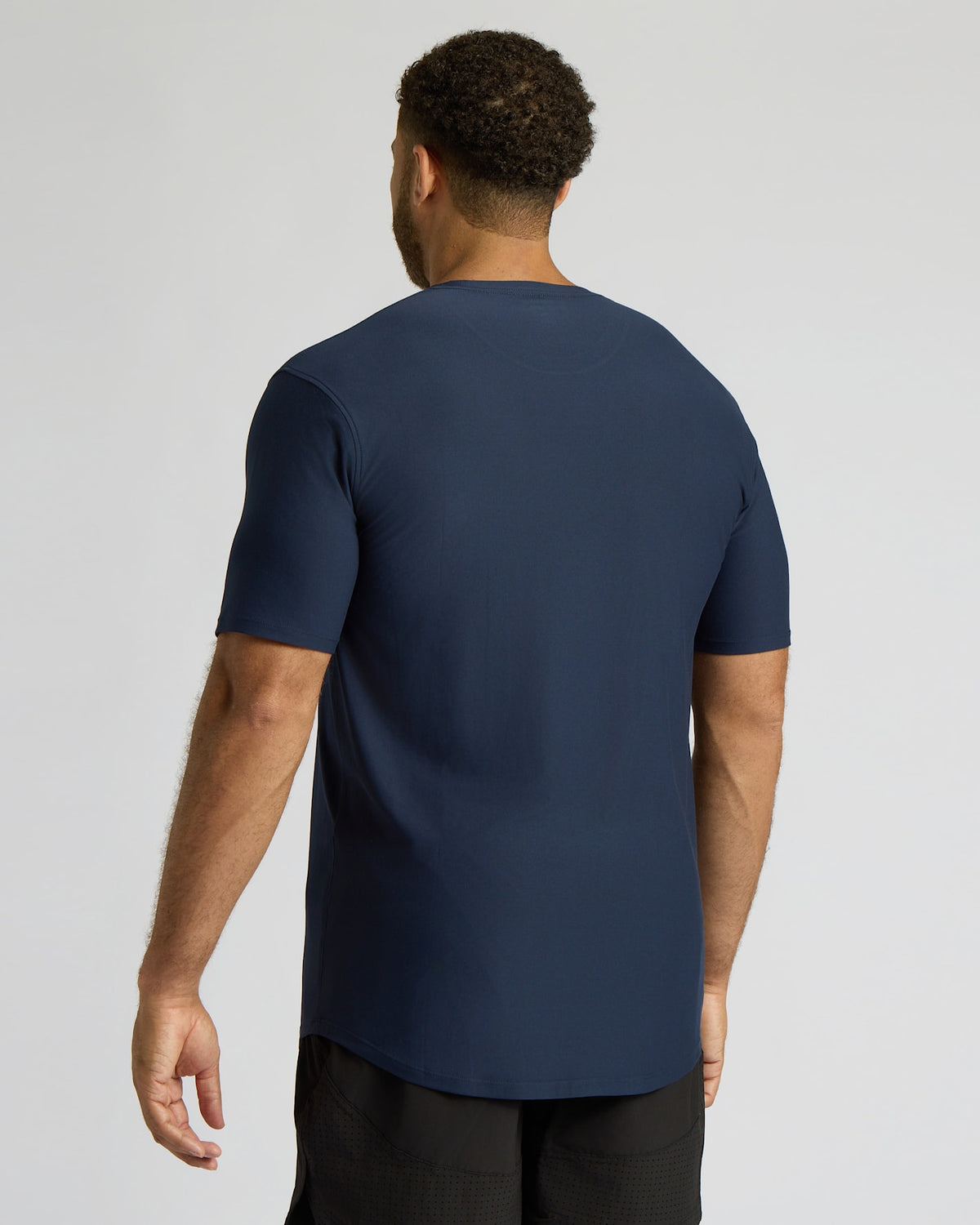 Man wearing a navy blue t-shirt on a light gray background