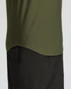 Close-up of a person wearing an olive green athletic top and black shorts against a light gray background.