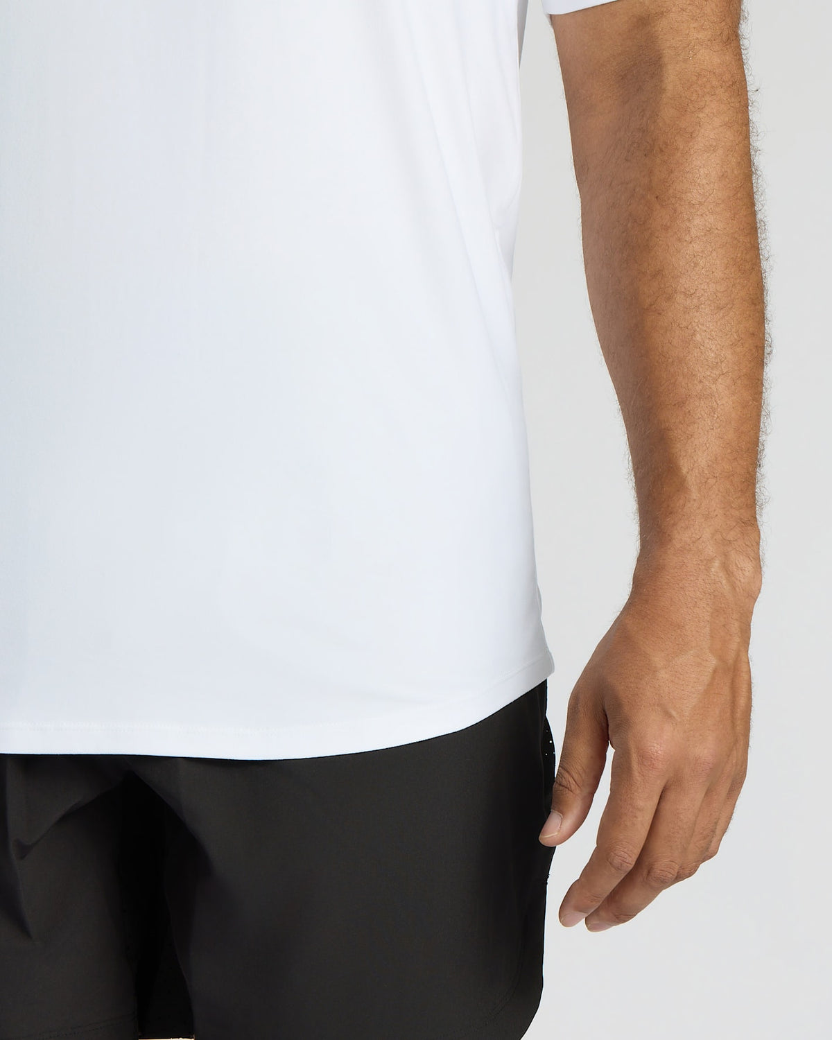 Person wearing a white shirt and black pants on a plain background