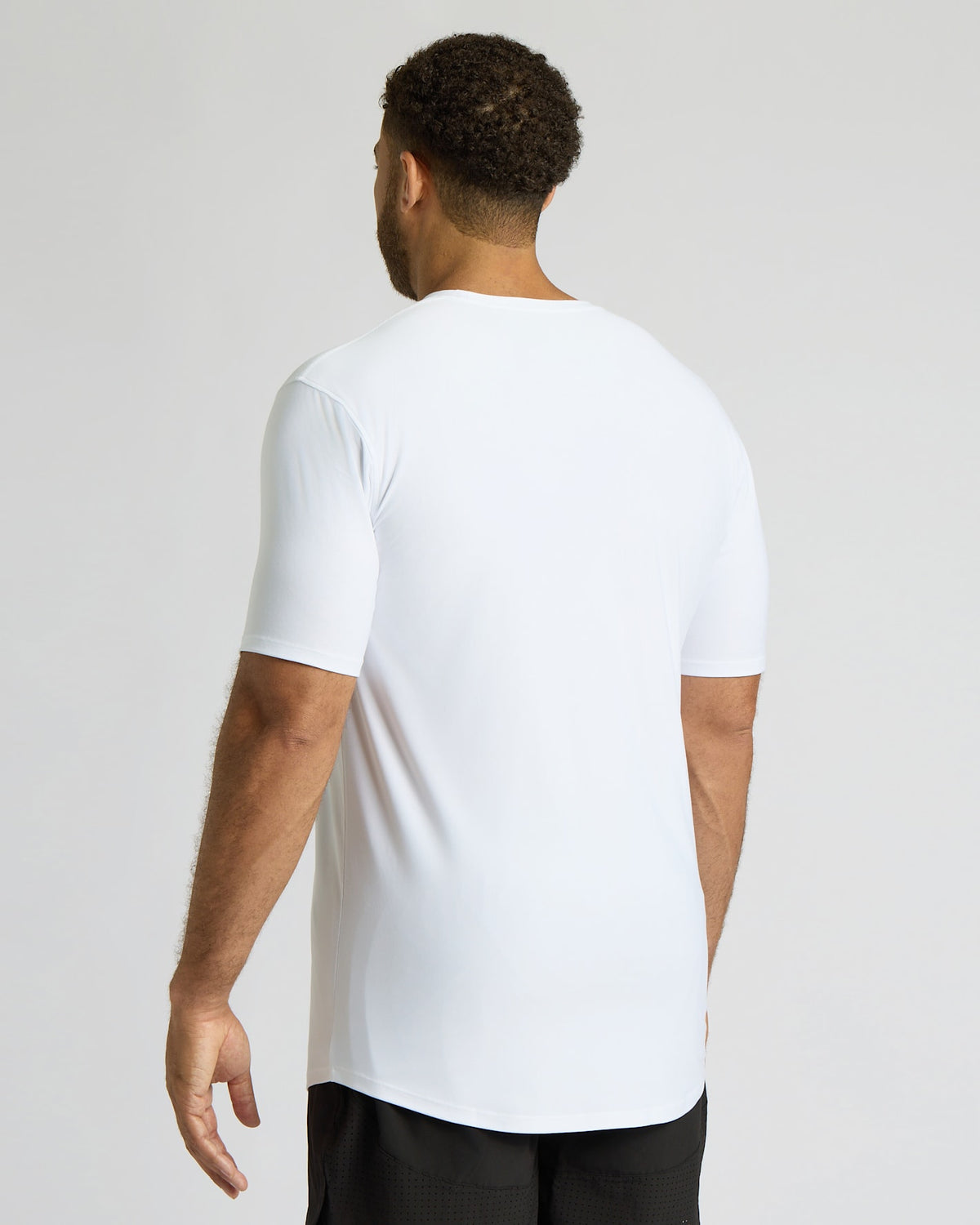 Man wearing a white t-shirt on a plain background