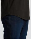 Close-up of a man wearing the All Black Heavyweight Curved Hem Crew 6-Pack shirt paired with dark blue jeans, highlighting the curved hem design in a men's basics style.