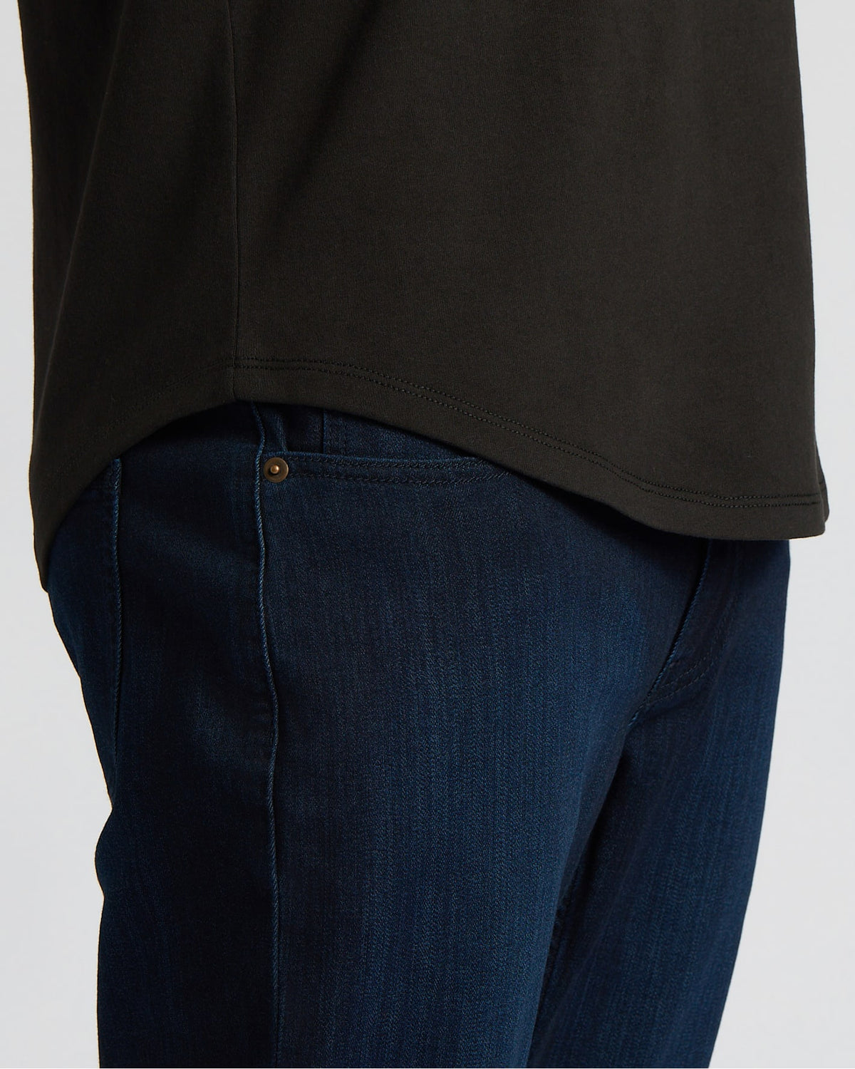 Close-up of a man wearing the All Black Heavyweight Curved Hem Crew 6-Pack shirt paired with dark blue jeans, highlighting the curved hem design in a men's basics style.