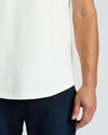 Close-up of a man wearing the All White Heavyweight Curved Hem Crew 3-Pack t-shirt paired with dark jeans, showcasing the shirt’s curved hem detail and heavyweight fabric in a men's basics style.