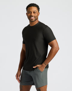 True ClassicMan modeling Black Active Crew Neck Tee with grey shorts, smiling.