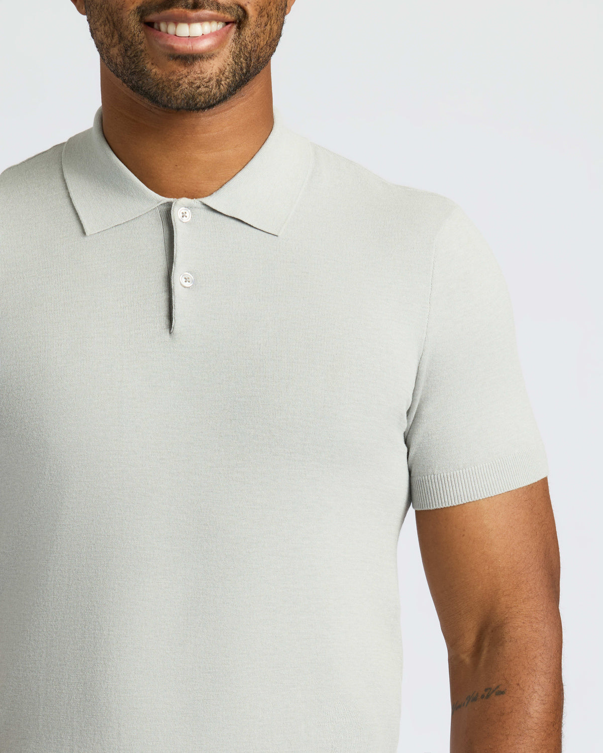 Man wearing Classic Polo with two-button placket and visible forearm tattoo.