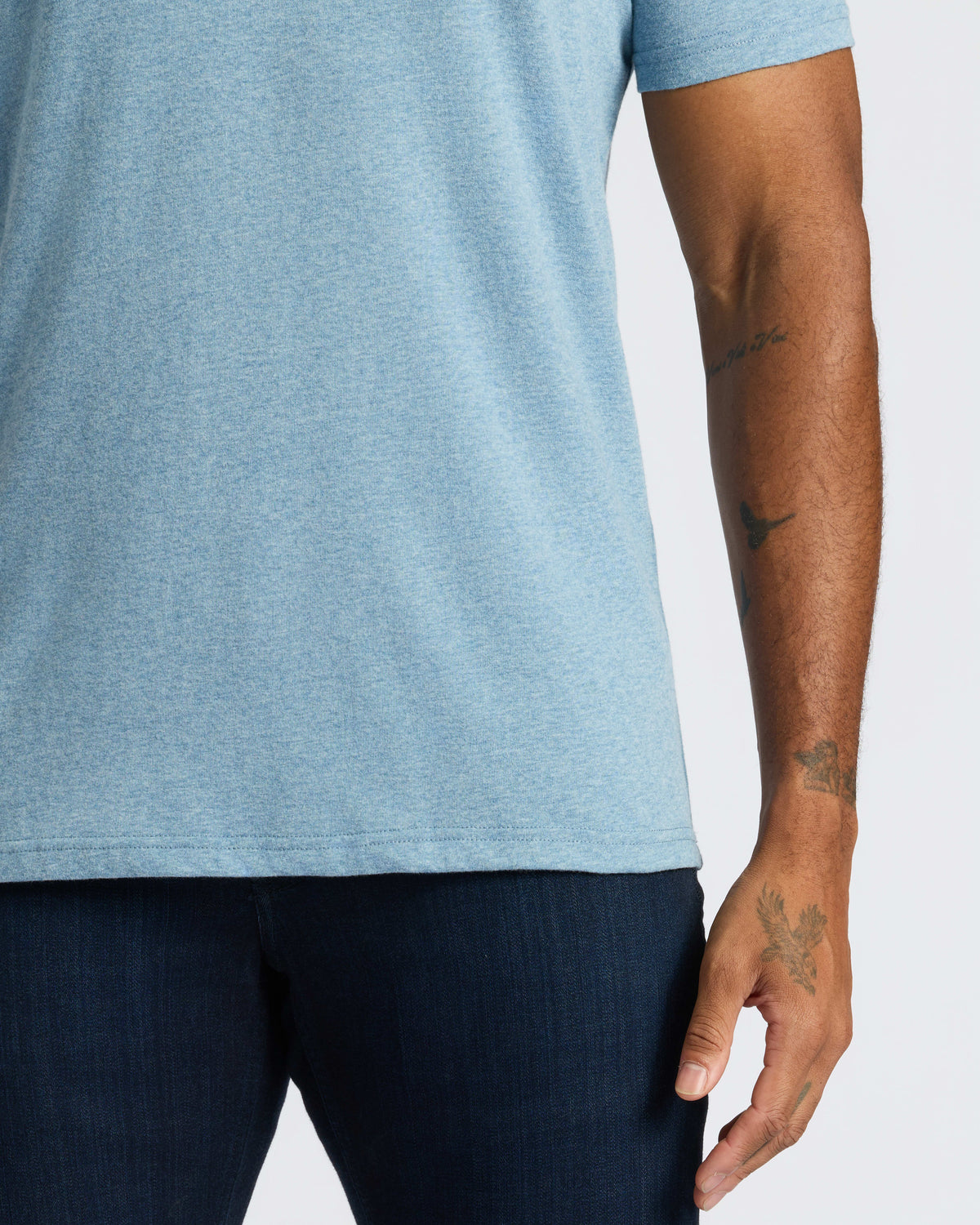 Person wearing Classic V-Neck tee with tattoos visible on forearm.