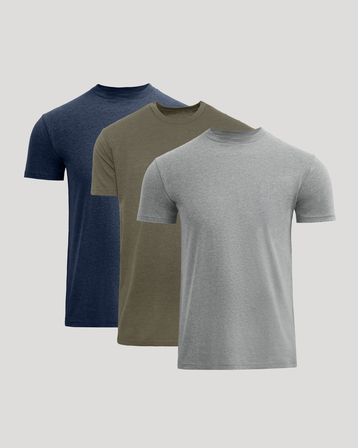Three short-sleeve crew-neck t-shirts in navy blue, olive green, and heather gray, arranged in a layered overlapping display on a light gray background.