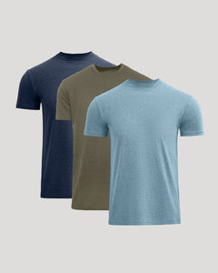 Three short-sleeve crew-neck t-shirts in navy blue, olive green, and light blue, arranged in a staggered overlapping layout on a solid light gray background.