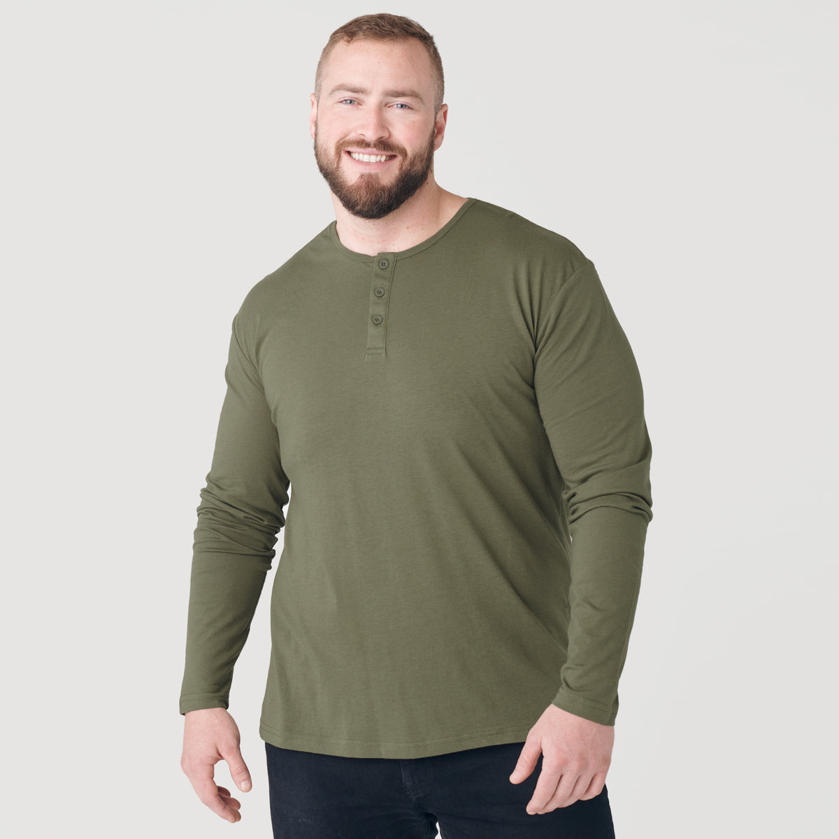 Man wearing Military Green Classic Long Sleeve Henley, smiling against plain background.