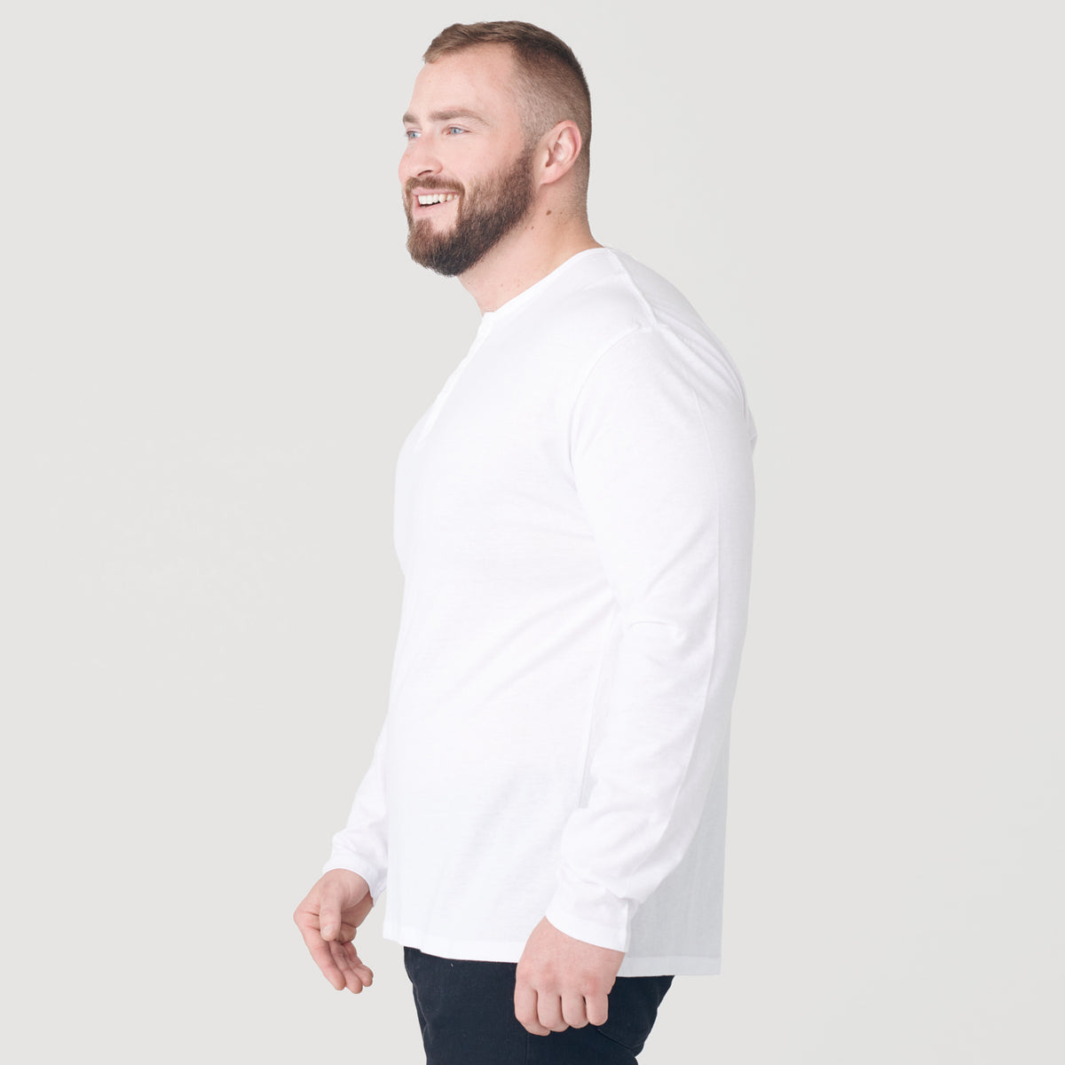 Man in White Classic Long Sleeve Henley, smiling in side profile.