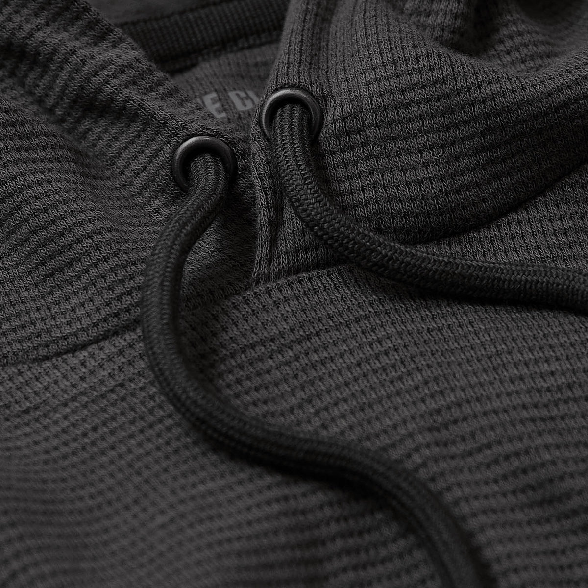 Carbon Waffle Hoodie with metal eyelets and drawstring on waffle-knit fabric.