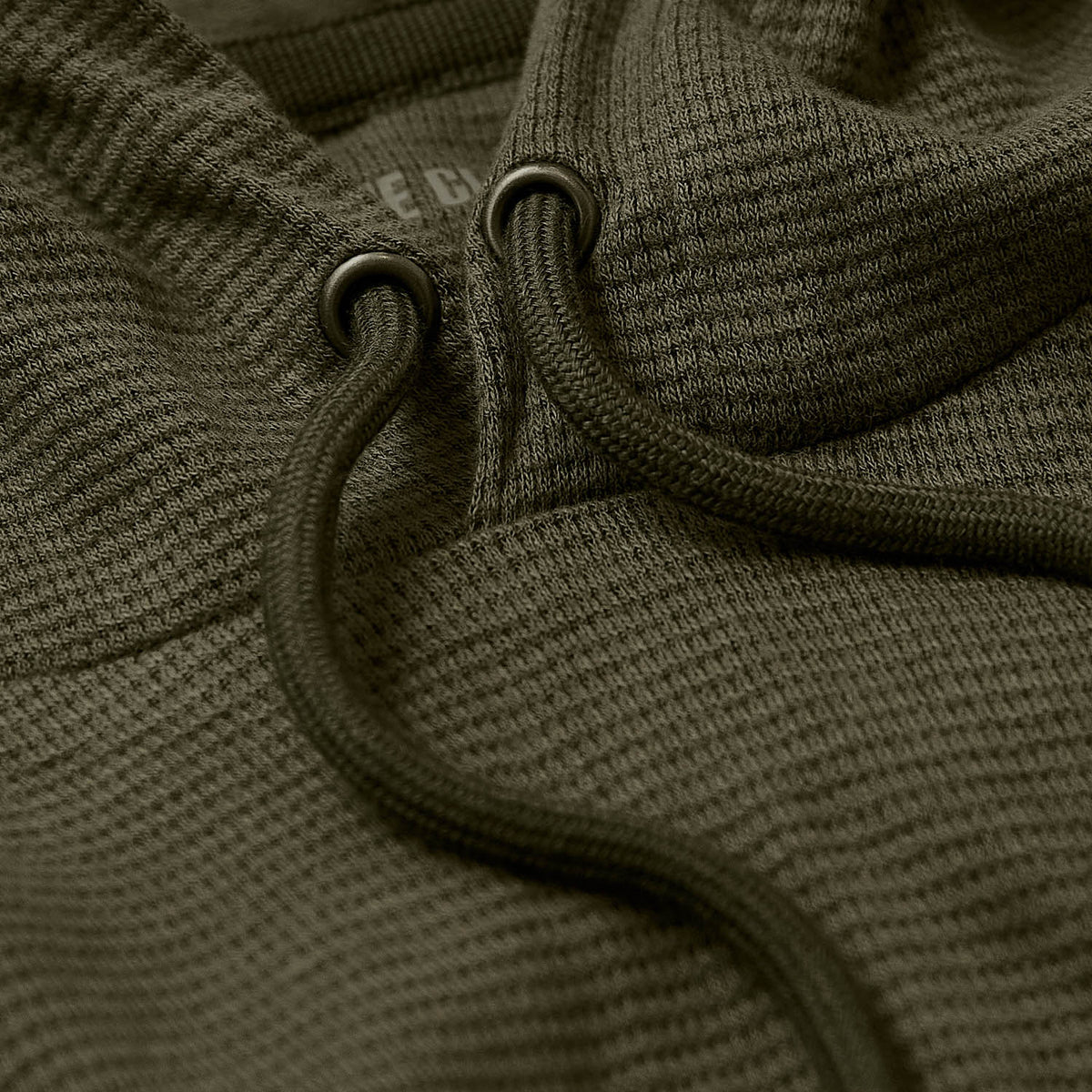 Military Green Waffle Hoodie close-up showing textured fabric and drawstring.